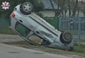 Samochód koloru szarego leżący na dachu