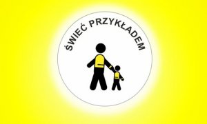 Na żółtym tle białe kółko a w nim czarny napis: świeć przykładem, dwa czarne ludziki ubrane w kamizelki z elementami odblaskowymi