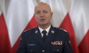 Komendant Główny Policji na tle flag państwowych