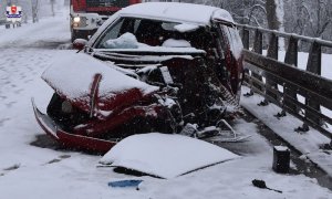 Uszkodzony samochód stoi na jezdni, a za nim wóz strażacki