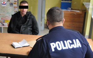 Policjant wykonuje czynności z zatrzymanym mężczyzną