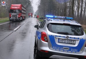 Miejsce wypadku drogowego. Na jezdni stoi samochód ciężarowy