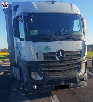 Samochód ciężarowy marki Mercedes Actros wraz z naczepą stoi na zatoczce autobusowej