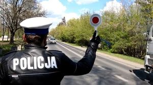 policjant zatrzymuje pojazdy do kontroli tarczą