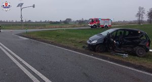 Mercedes z uszkodzeniami lewej strony stoi na trawiastym poboczu