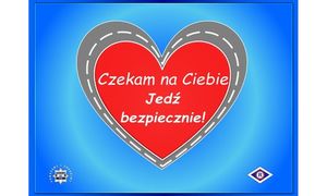 Na niebieskim tle czerwone serce w szarej obwolucie stylizowanej na jezdnię i w środku napis: Czekam na Ciebie - Jedź bezpiecznie! Po lewej stronie poniżej gwiazda policyjna a po prawej logo ruchu drogowego