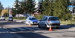 Miejsce wypadku drogowego. Samochód marki Renault stoi na przejściu dla pieszych, a przed nim oznakowany radiowóz.