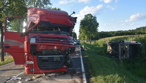 Samochód ciężarowy marki Daf z uszkodzeniami kabiny stoi na jezdni. W rowie leży ciężarowa scania.