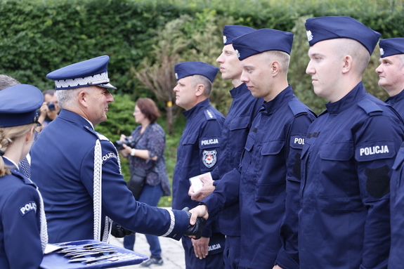 Komendant Wojewódzki Policji w Lublinie nadispektor Artur Bielecki wręcza legitymacje nowemu policjantowi.