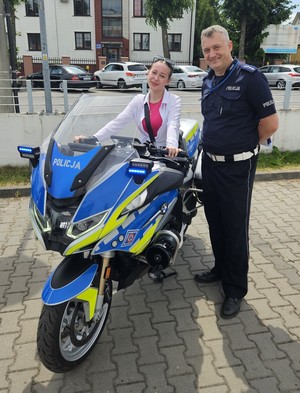 Policjant stoi przy motocyklu
