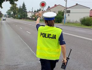 Policjantka z uniesioną tarczą do zatrzymywania pojazdów