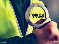 Dłoń trzymająca kajdanki oraz napis Policja