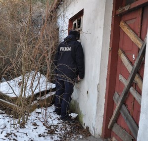 Policjant dokonujący sprawdzenia pustostanu