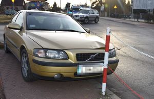 Samochód marki Volvo stoi na chodniku za nim Opel i radiowóz oznakowany