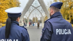 policjanci przed bramą cmentarza