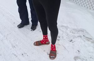 nogi zatrzymanego 27-latka w skradzionych ciapach i skarpetkach, obok nogi policjanta