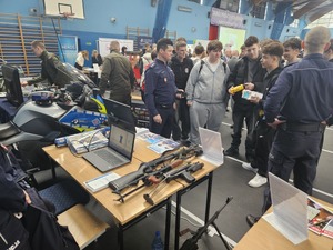 Policjant rozmawia z młodzieżą w trakcie trwających targów