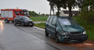 Miejsce zderzenia aut. Samochody stoją na jezdni, a za nimi wóz strażacki