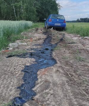 Uszkodzony samochód stoi na gruntowej drodze