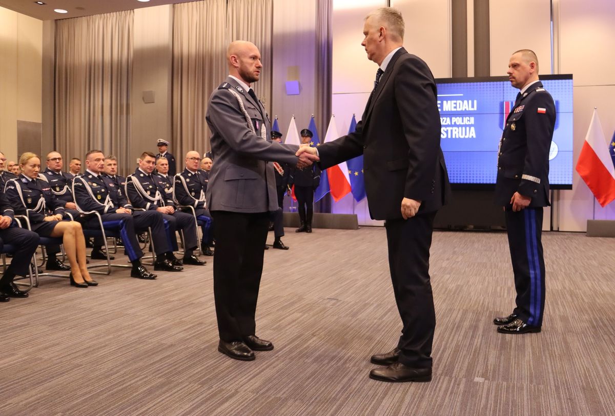 policjant odbiera medal od Ministra SWiA